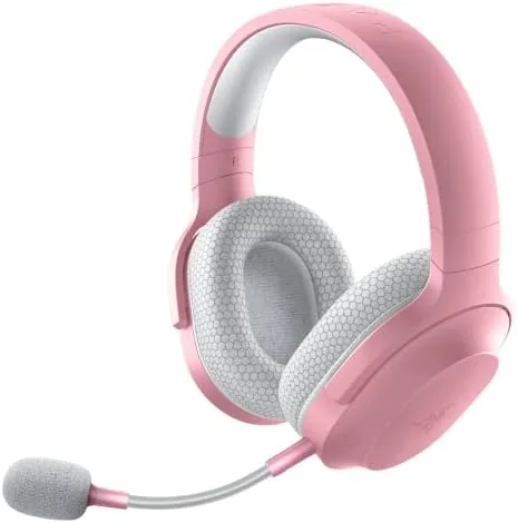 Razer Barracuda X headset in pink resting on a desk with the USB-C dongle nearby