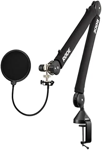 Rode PSA1+ boom arm clamped to the edge of a desk holding a condenser microphone