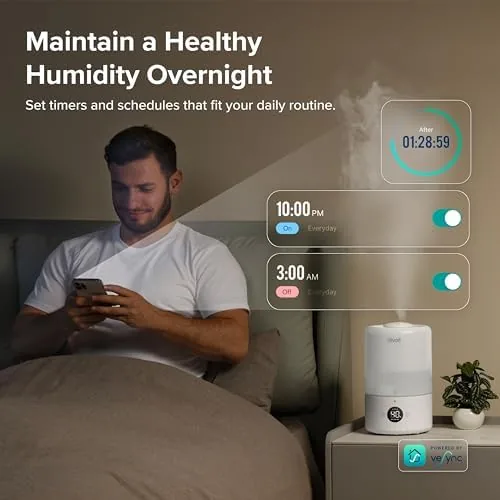 The humidifier running at night with the mist nozzle rotated toward the bed