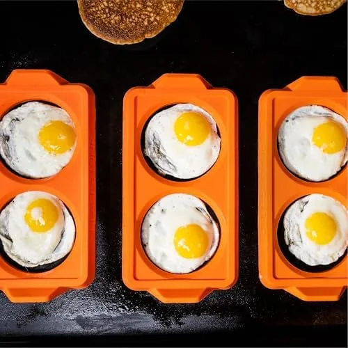 Raw egg cracked inside a Blackstone silicone ring on a griddle