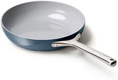 The navy Caraway ceramic frying pan on a stovetop