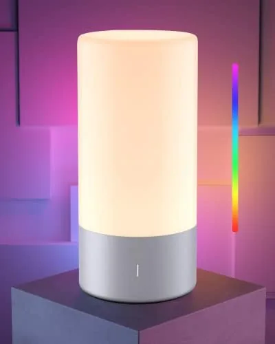 The ROOTRO lamp glowing warm white on a nightstand