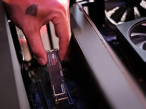 The 990 PRO drive on a desk next to a laptop being used for video editing