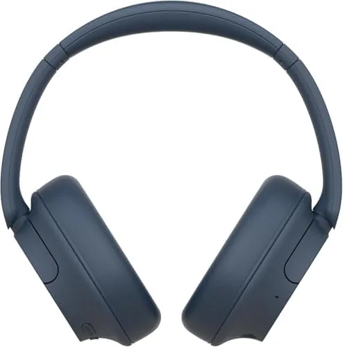 A person wearing the blue WH-CH720N while listening to music in a living room