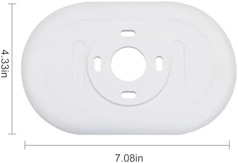 Hand installing the Nest thermostat and trim plate on a wall