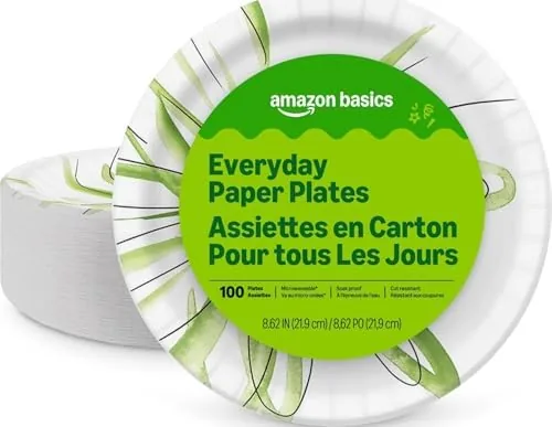 A stack of Amazon Basics paper plates beside a prepared dinner plate