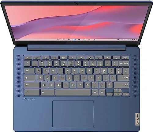 Chromebook on a library table with a book and notebook