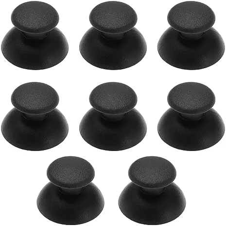 Eight black rubber thumbstick caps arranged in a grid on a table