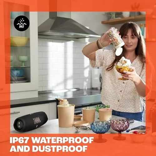 The JBL Charge 5 Wi-Fi being carried by its strap outdoors