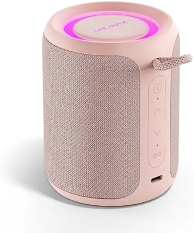The pink IP67 Bluetooth speaker on a beach towel beside a pool