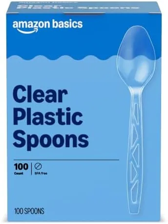 A stack of clear plastic spoons from the Amazon Basics hundred pack on a table