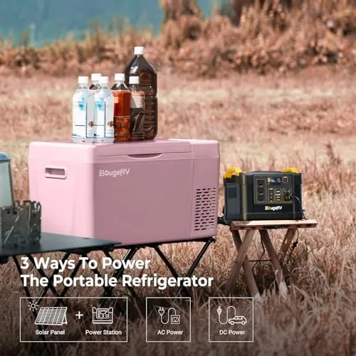 The pink BougeRV fridge open at a campsite with cold drinks and food inside