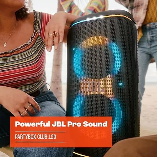 The JBL PartyBox Club 120 set up at an outdoor gathering with the wheels and handle visible