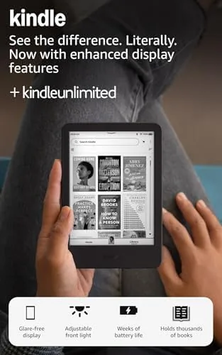 The new Amazon Kindle 16 GB in black lying on a desk beside a phone