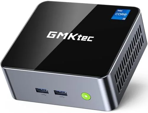 The GMKtec M3 mini PC in black sitting on a desk beside a monitor