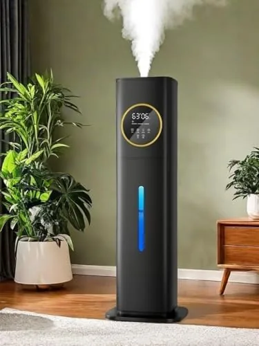 Black 8L humidifier standing on a bedroom nightstand with the tank window visible
