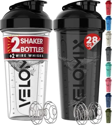 Two VELOMIX 28oz protein shaker bottles in black and transparent on a kitchen counter