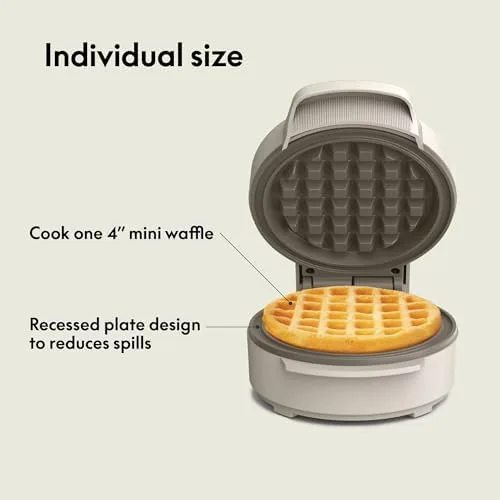 Stacked golden waffles topped with berries and syrup on a white plate
