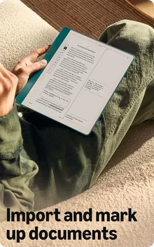 The Kindle Scribe on a desk with a book, pen, and coffee showing a work setup