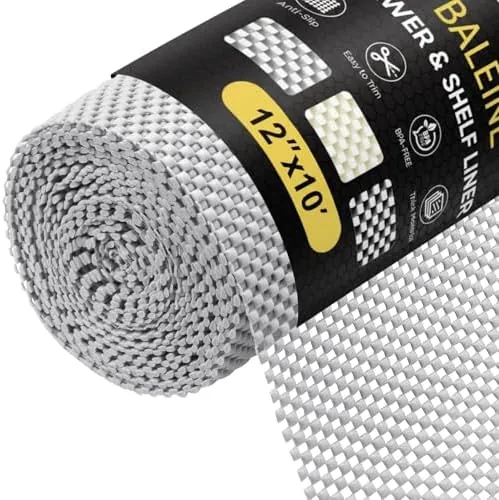 The BALEINE cabinet liner roll in gray unrolled across a kitchen counter with scissors
