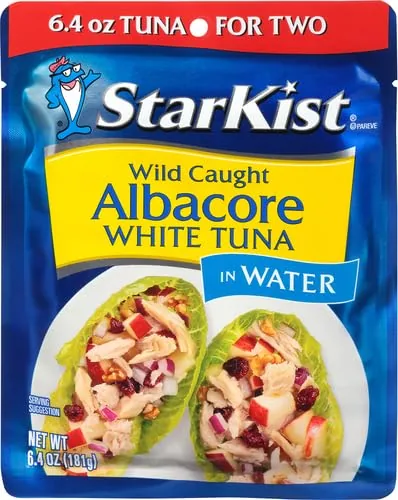 Albacore tuna flakes on a fork being tasted