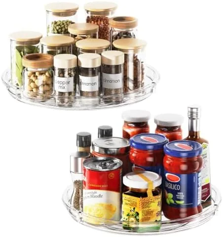 Two clear lazy susans with spice jars arranged on a kitchen counter