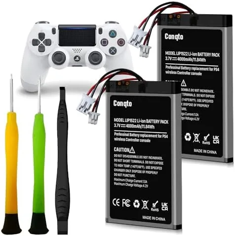 Two PS4 controller batteries with the repair tool kit laid out on a desk