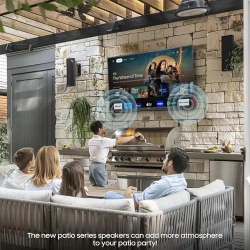Outdoor TV glowing on a patio at dusk beside outdoor furniture