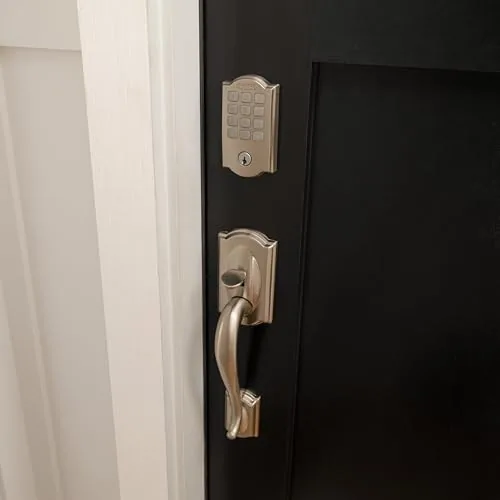 A hand unlocking the door by pressing the keypad code at night