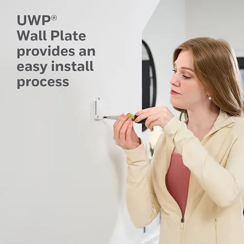The thermostat installed in a living room next to a plant