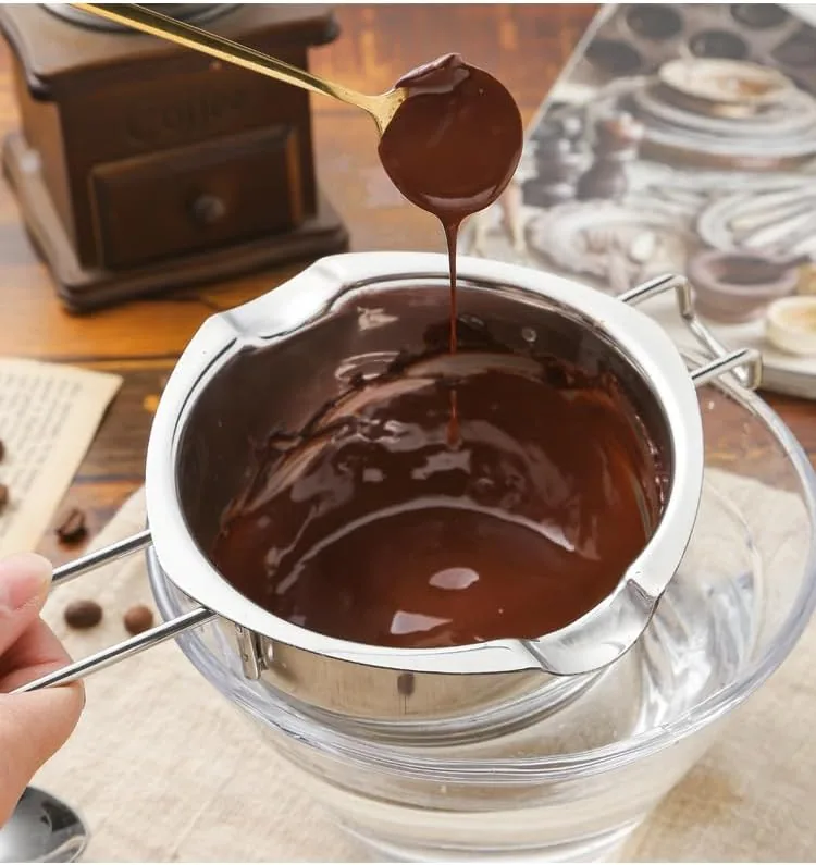 Melted candle wax being poured from the melting pot into candle molds