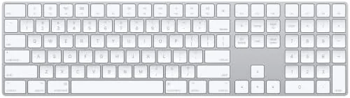 The white Apple Magic Keyboard with Numeric Keypad on a desk next to a Mac