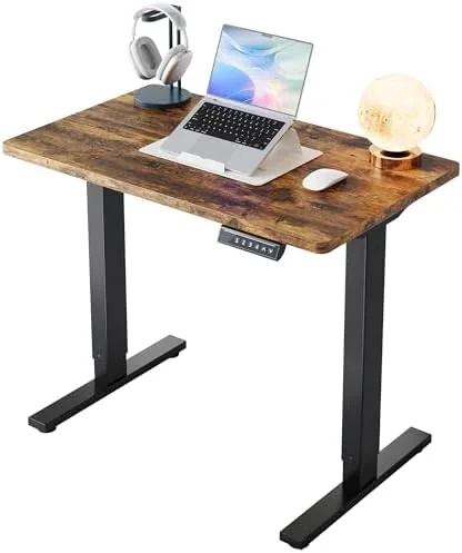 The HUANUO 32x19 inch electric standing desk in rustic brown set up in a small home office