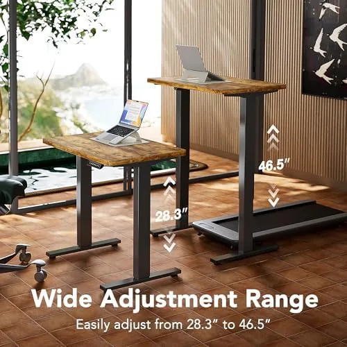 The desk raised to standing height with a monitor, laptop, and keyboard on top
