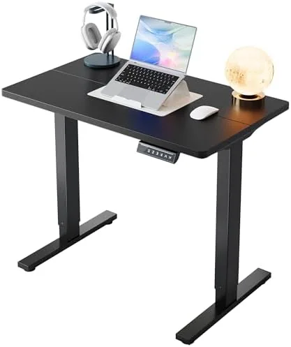 The HUANUO 32x19 inch electric standing desk in black set up in a small room