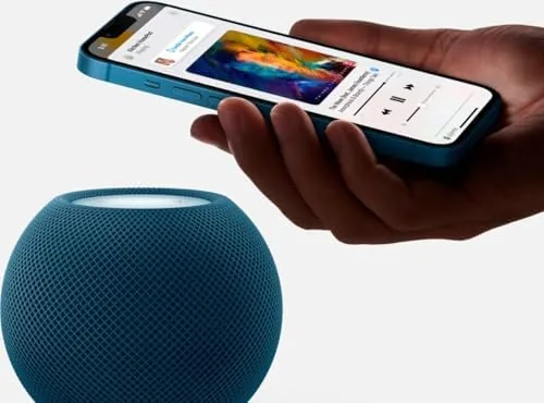 Blue HomePod mini in a bedroom setup playing music