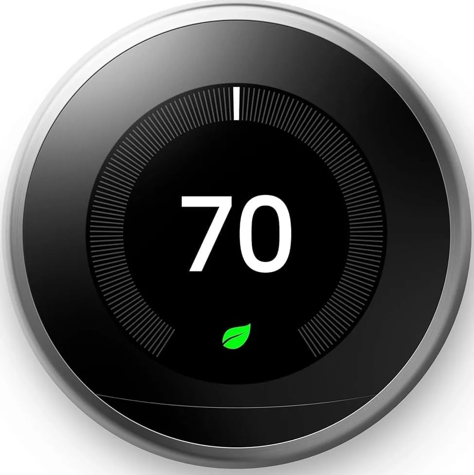 The stainless steel Google Nest Learning Thermostat mounted on a hallway wall