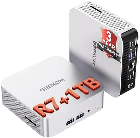 The GEEKOM A8 mini PC sitting on a desk beside a monitor