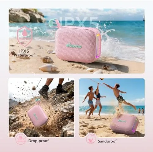 The pink speaker on a picnic table at dusk with the LED light glowing
