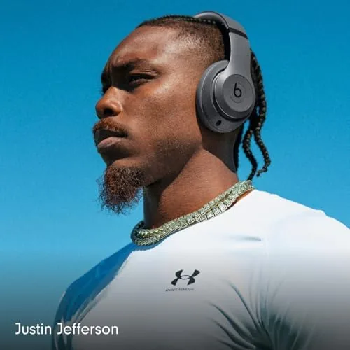 A commuter wearing the Studio Pro headphones on a city train