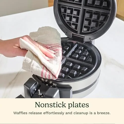 Two freshly cooked Belgian waffles being lifted from the plates