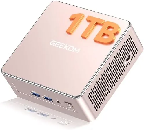 The GEEKOM A5 mini PC sitting on a desk next to a monitor