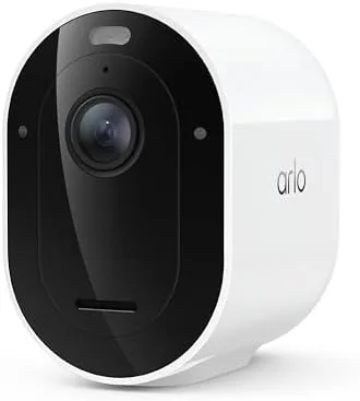 White Arlo Pro camera mounted on a back wall overlooking a yard