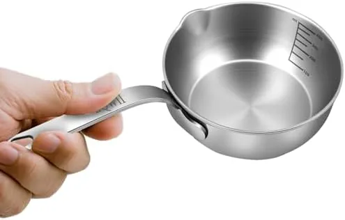 The 18/10 stainless steel butter warmer on a gas stovetop with butter melting inside