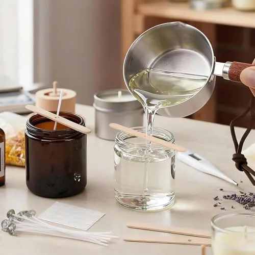 Hot soy wax being poured cleanly from the spout into a glass jar