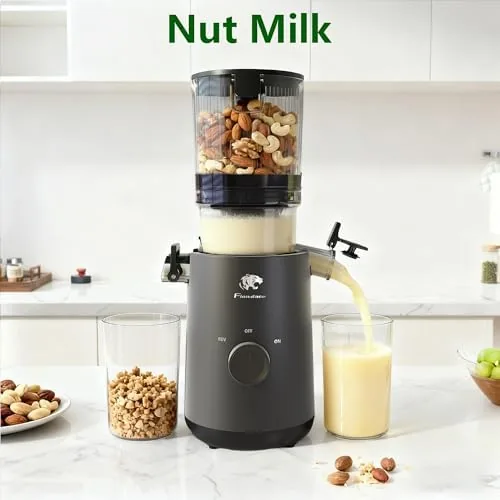 A fresh glass of orange juice next to the assembled juicer