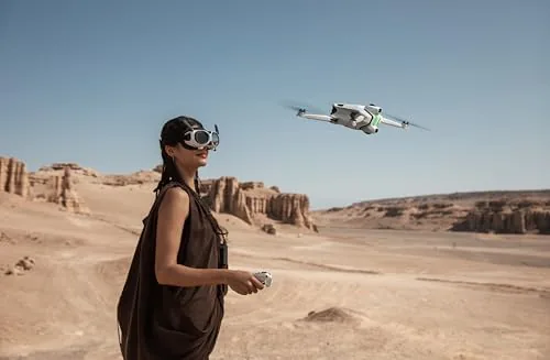 A traveler holding the folded A1 drone and its carry case beside a daypack