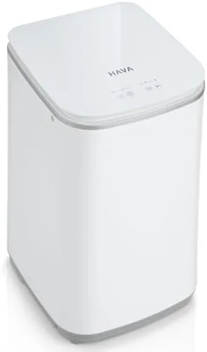 The portable washing machine sitting on a bathroom counter with its lid open
