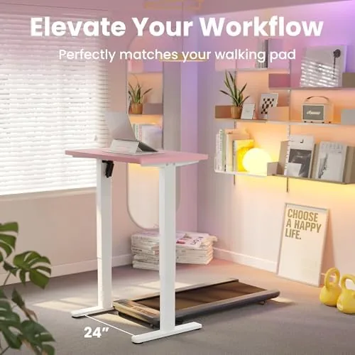 The desk raised to standing height with a laptop and monitor on top in a bright room