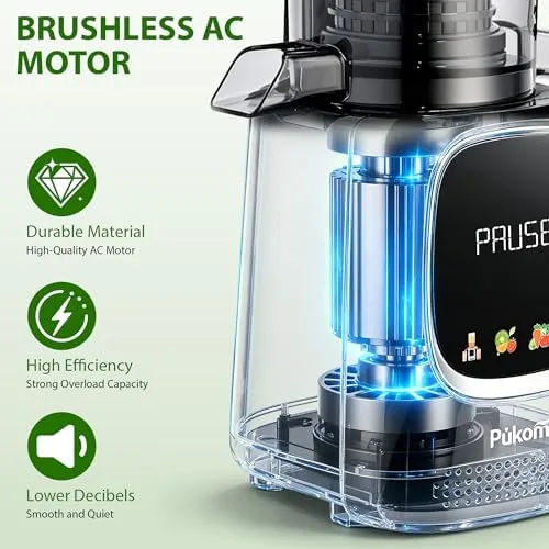 A glass of green juice next to the Pukomc juicer with a pile of fresh vegetables